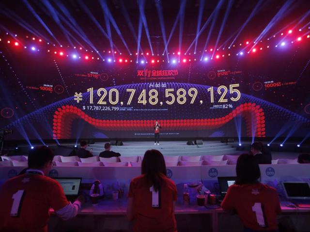 Attendants sit in front of a giant screen showing a total sales transacted of e-commerce giant Alibaba, on the "Singles' Day" global online shopping festival in Shenzhen, southern China's Guangdong province.(AP Photo)