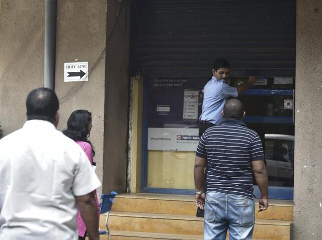 A security guard shuts down an ATM kiosk at Ghatkopar, as it runs out of cash. (Arijit Sen/HT PHOTO) 