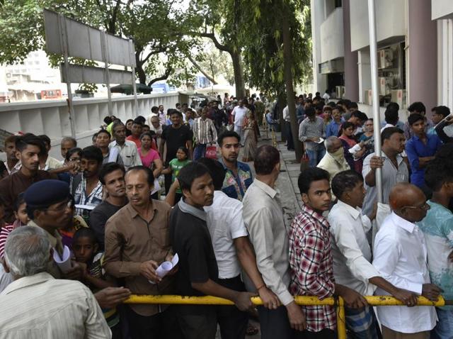 People stand outside the branch of a bank at Ghatkopar. (Arijit Sen/HT PHOTO) 