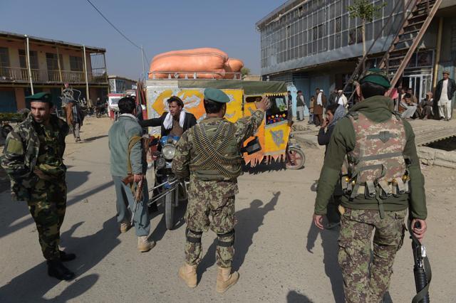 Afghan security personnel stop people as they block the road near the largest US military base in Bagram. (AFP) Afghan security personnel stop people as they block the road near the largest US military base in Bagram. (AFP)