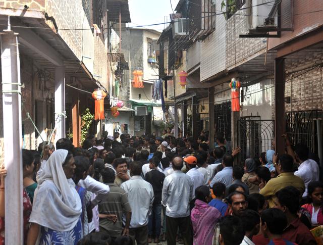 People gather outside Mangesh Anerao’s home in Sakinaka, on Saturday. (Prashant Waydande / Hindustan Times)