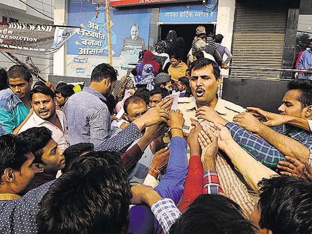 A policeman tries to manage a queue outside a bank in Jasola in New Delhi on Friday.(Burhaan Kinu/Hindustan Times) A policeman tries to manage a queue outside a bank in Jasola in New Delhi on Friday.(Burhaan Kinu/Hindustan Times)