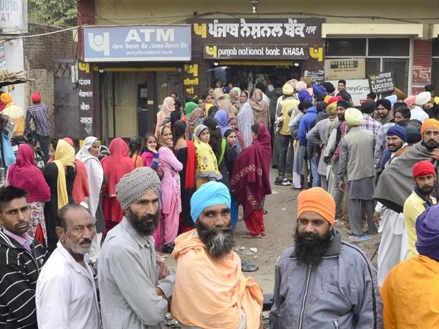 People in queues outside a Punjab National Bank branch at Khasa near Amritsar on Saturday, November 12.(Sameer Sehgal/HT Photo)