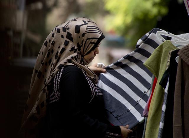 An Egyptian woman buys a second-hand shirt at a popular market in Cairo, Egypt. (AP) An Egyptian woman buys a second-hand shirt at a popular market in Cairo, Egypt. (AP)