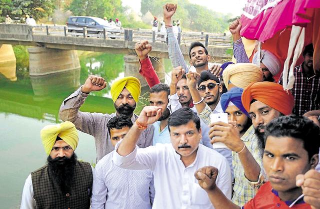 AAP Party leader Sanjay Singh with APP party workers holding a protest at SYL Canal near Ghanour Town in Patiala on Friday. (Bharat Bhushan/HT Photo)