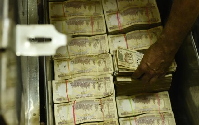 An employee stacks old currency notes at a cash counter at Allahabad Bank in Parliament Street, Delhi. (Vipin Kumar/HT Photo) An employee stacks old currency notes at a cash counter at Allahabad Bank in Parliament Street, Delhi. (Vipin Kumar/HT Photo)