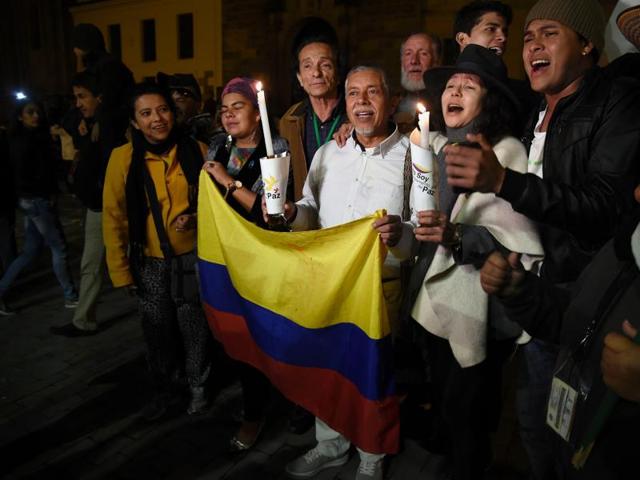 People celebrate on Bogota's main square on Saturday after the Colombian government and Marxist FARC rebels signed a new and revised peace deal to end 52 years of civil war. (AFP) People celebrate on Bogota's main square on Saturday after the Colombian government and Marxist FARC rebels signed a new and revised peace deal to end 52 years of civil war. (AFP)