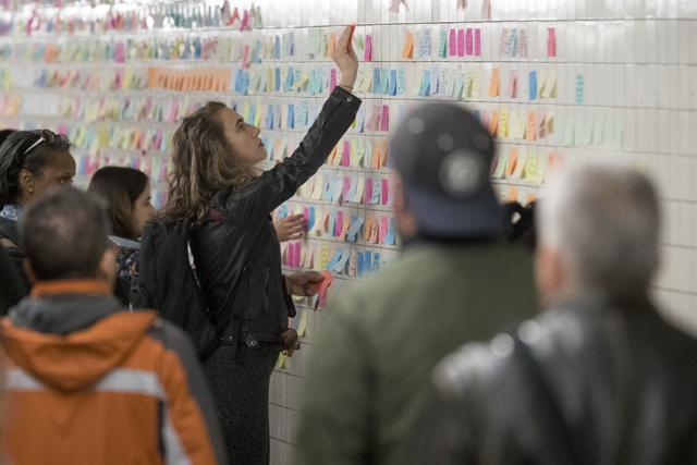 A commuter places a Post-it note on the "Subway Therapy" wall in New York. (AP) A commuter places a Post-it note on the "Subway Therapy" wall in New York. (AP)