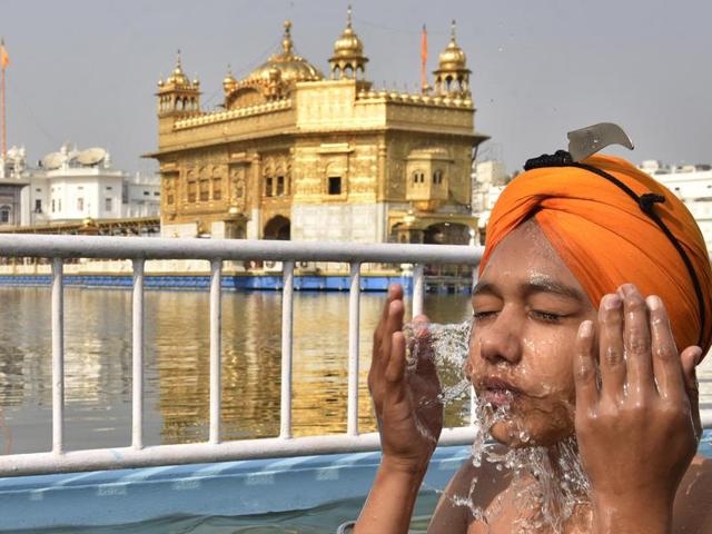 A devotee takes a dip in the holy sarovar (pond) at the Golden Temple on the birth anniversary of Guru Nanak Dev, in Amritsar on Monday. (Gurpreet Singh/HT Photo)