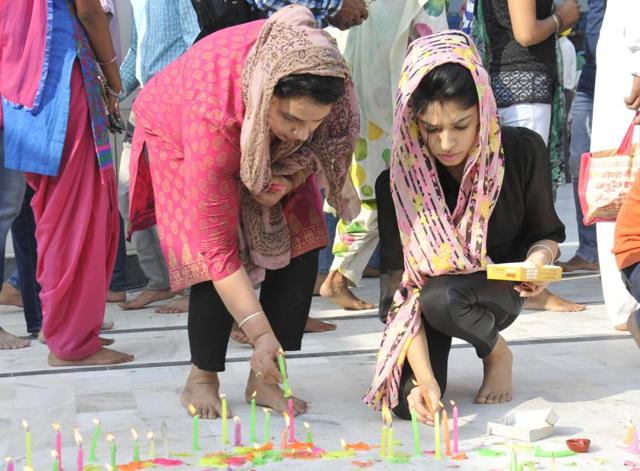 Lighting candles to mark Guru Nanak’s birth anniversary, at Gurdwara Nada Sahib in Panchkula on Monday. (Sant Arora/HT Photo)
