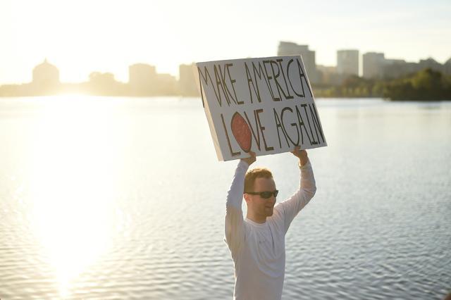 A protester against President-elect Republican Donald Trump holds a sign as he jogs around Lake Merritt in Oakland, California on Sunday. (Reuters) A protester against President-elect Republican Donald Trump holds a sign as he jogs around Lake Merritt in Oakland, California on Sunday. (Reuters)