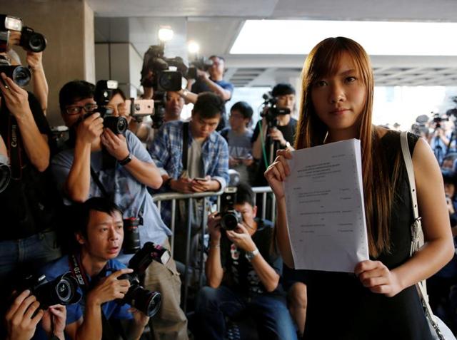 Democratically-elected legislators Yau Wai-ching holds the judgement as she leaves the High Court after court rules pro-independence lawmakers barred in Hong Kong on Tuesday.(Reuters)