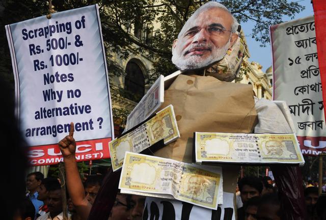 Leftist activists shout slogans against Indian prime minister Narendra Modi as they carry his effigy, decorated with posters of rupee notes, during a protest rally in Kolkata on November 14, 2016. Prime Minister Narendra Modi on November 14, urged Indians to give him more time to resolve a cash crunch that followed the withdrawal of high-value banknotes from circulation, as rival politicians lashed out at his handling of the crisis. / AFP PHOTO / Dibyangshu SARKAR (AFP) Leftist activists shout slogans against Indian prime minister Narendra Modi as they carry his effigy, decorated with posters of rupee notes, during a protest rally in Kolkata on November 14, 2016. Prime Minister Narendra Modi on November 14, urged Indians to give him more time to resolve a cash crunch that followed the withdrawal of high-value banknotes from circulation, as rival politicians lashed out at his handling of the crisis. / AFP PHOTO / Dibyangshu SARKAR (AFP)