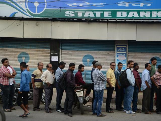 Customers queue up outside an ATM to withdraw money in Siliguri.(AFP Photo)