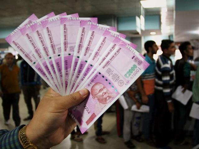 A man shows new Rs 2000 notes at a bank in Jammu.(PTI Photo)