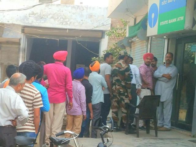 Poeple waiting outside an ATM in Patiala on Tuesday. (HT Photo) Poeple waiting outside an ATM in Patiala on Tuesday. (HT Photo)