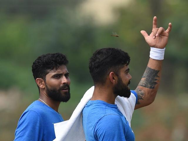 India's captain Virat Kohli (R) gestures while giving bowling tips to Ravindra Jadeja on Wednesday. Jadeja went wicketless in England’s second innings in Rajkot. (AFP)