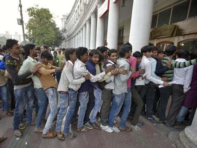 People stand in queue outside the Bank at Connaught Place in New Delhi on Tuesday.(Ravi Choudhary/Hindustan Times)