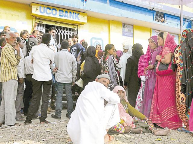 People stand outside an ATM in Jaipur on Wednesday. (HT Photo)
