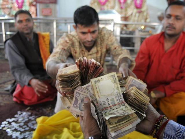 Temple priests at Sanatan Dharm Temple in Sector 19, Noida, checking Rs 500 and Rs 1000 notes in the donation box of the temple. (Sunil Ghosh /HT Photo) Temple priests at Sanatan Dharm Temple in Sector 19, Noida, checking Rs 500 and Rs 1000 notes in the donation box of the temple. (Sunil Ghosh /HT Photo)