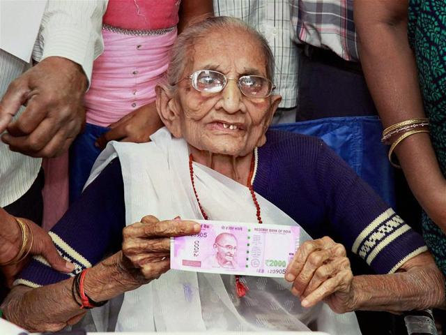 Prime Minister Narendra Modi's mother Heeraben Modi shows the 2000 rupees note after exchanging the old 500 and 1000-rupee notes at a bank in Gandhinagar on Tuesday.(PTI) Prime Minister Narendra Modi's mother Heeraben Modi shows the 2000 rupees note after exchanging the old 500 and 1000-rupee notes at a bank in Gandhinagar on Tuesday.(PTI)