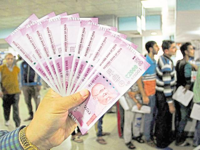 A bank officer shows new Rs 2000 notes in a bank in Jammu on Sunday.(PTI Photo)