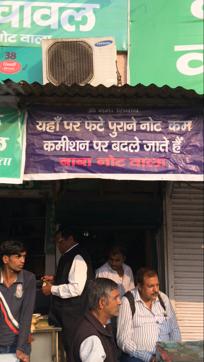 Deepak Singh (in brown jacket) outside his shop that exchanges old notes in Old Delhi’s Fatehpuri. (HT PHOTO)