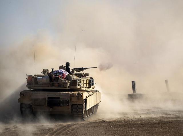 Dust rises as a tank from the Iraqi army fires at a suspect car approaching their position during a military operation to retake Mosul from the Islamic State group jihadists. (AFP File Photo)