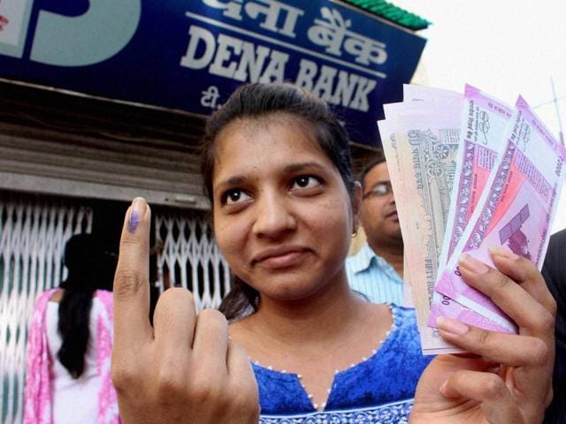 A woman shows her inked finger after exchanging old currency from a bank in Bhopal on Wednesday.(PTI)