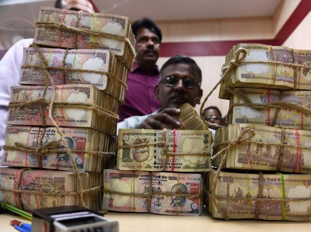 A bank employee counting the bundles of the received currency of old Rs 500 and 100 notes at cash counter at a Punjab National Bank branch in Chennai on Wednesday.(PTI Photo)