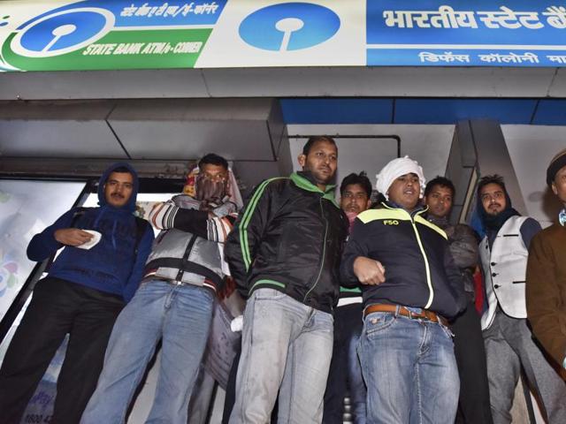 People wait outside an SBI branch in New Delhi on Friday.(Sanjeev Verma/HT PHOTO)