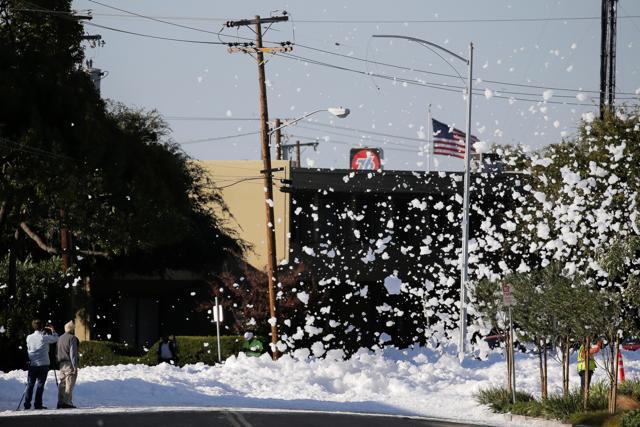 Fire retardant foam is seen blowing in the wind after a fire alarm malfunctioned in a hangar according to local media, near the San Jose airport in Santa Clara, California. (Reuters)