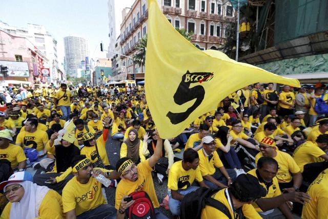 Protesters occupy a street during a rally in downtown Kuala Lumpur on Saturday. Malaysian police detained 12 activists and tightened security ahead of the rally by electoral reform group Bersih seeking Prime Minister Najib Razak's resignation over a financial scandal.  (AP)
