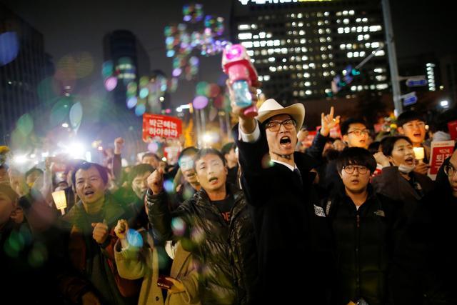 People chant slogans on a road leading to the Presidential Blue House during a protest calling South Korean President Park Geun-hye to step down, in Seoul on Saturday. (Reuters) People chant slogans on a road leading to the Presidential Blue House during a protest calling South Korean President Park Geun-hye to step down, in Seoul on Saturday. (Reuters)