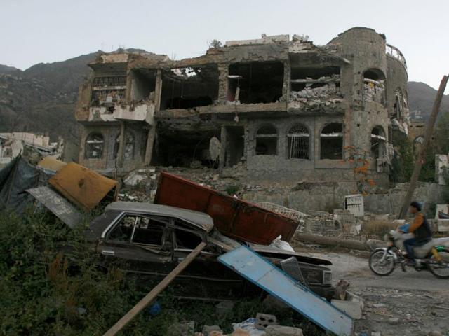 A man rides a motorbike past a house destroyed during recent battles between Houthi fighters and pro-government fighters in the southwestern city of Taiz, Yemen. (Reuters Photo)