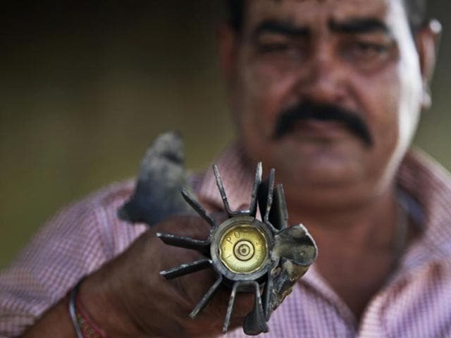 A villager displays a mortar shell fired from the Pakistan side, at a residential area near in Pallanwala sector, of Jammu and Kashmir on Tuesday. (AP) A villager displays a mortar shell fired from the Pakistan side, at a residential area near in Pallanwala sector, of Jammu and Kashmir on Tuesday. (AP)