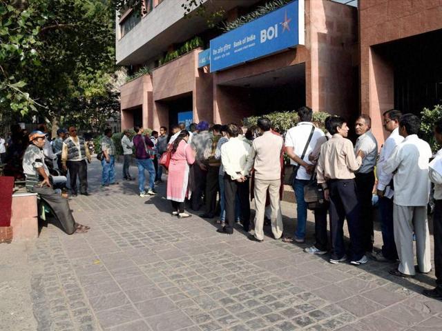 People stand in a queue to deposit/ exchange their old notes outside a bank in New Delhi on Saturday.(PTI)