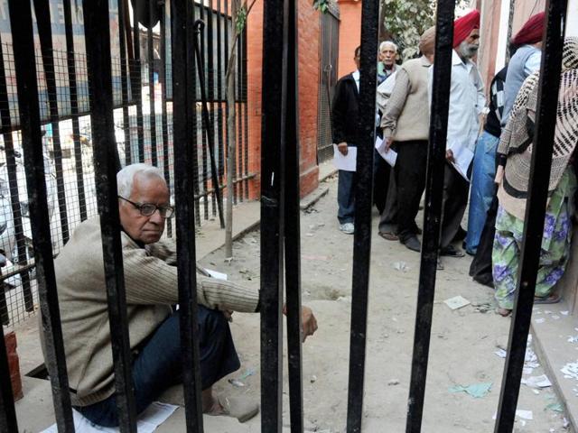 An elderly man sits as others stand in queue outside a SBI branch to exchange old notes, in Amritsar on Saturday. (PTI) An elderly man sits as others stand in queue outside a SBI branch to exchange old notes, in Amritsar on Saturday. (PTI)