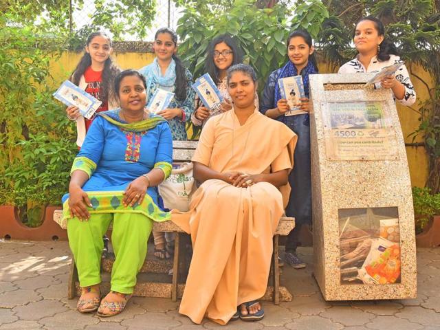 Stancy Estibiero (in blue and green) and Sister Jessy, principal, with ex-students of Mary Immaculate Girl’s High School with the bin and bench made of Tetra Paks in Kalina, Santacruz on Saturday.(Vidya Subramanian/HT)