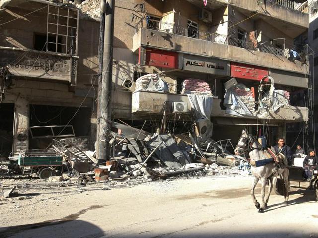 People ride a cart pulled by a horse near the damaged al-Hakeem hospital, in the rebel-held besieged area of Aleppo on Saturday. (Reuters) People ride a cart pulled by a horse near the damaged al-Hakeem hospital, in the rebel-held besieged area of Aleppo on Saturday. (Reuters)