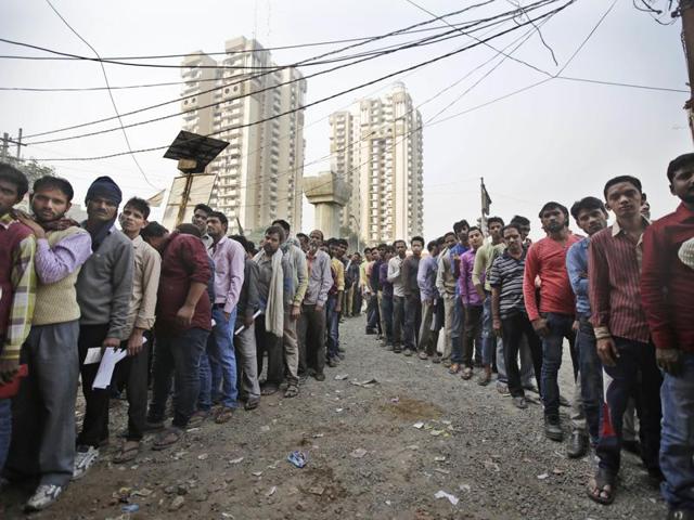 People stand in lines outside a bank to exchange or deposit discontinued currency notes in New Delhi.(AP)