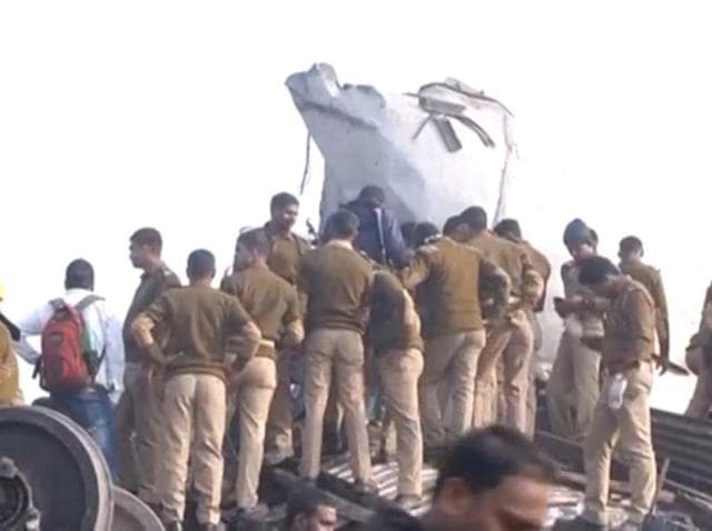 Police officers and people gather at the site where a train was derailed in Kanpur.(Reuters Photo)