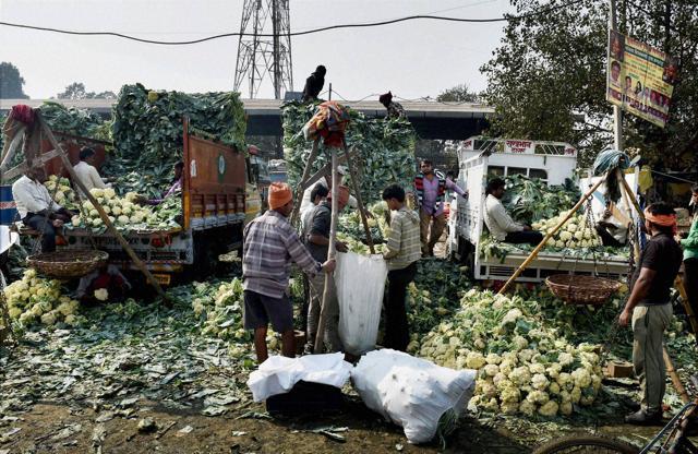 Vendors unloading vegetables from trucks at the Azadpur Mandi where business was badly hit due to demonetisation, in New Delhi. (PTI) Vendors unloading vegetables from trucks at the Azadpur Mandi where business was badly hit due to demonetisation, in New Delhi. (PTI)