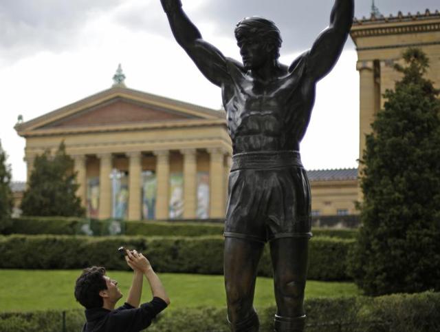 In this May 8, 2013, file photo, a tourist photographs a statue of the movie character Rocky Balboa outside the Philadelphia Museum of Art in Philadelphia. (AP Photo) In this May 8, 2013, file photo, a tourist photographs a statue of the movie character Rocky Balboa outside the Philadelphia Museum of Art in Philadelphia. (AP Photo)