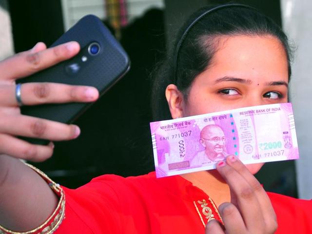 No selfie crunch: A woman strikes a new pose with a new Rs2,000 note. (mayur bargaje/ht photo) 