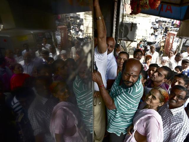 Rush hour: No, this is not Dadar station and people are not trying to board the train. They are  waiting in queue to exchange and deposit old Rs500 and Rs1,000  notes outside Bank of India’s  branch in Ghatkopar (West) in Mumbai.  (Arijit Sen/HT PHOTO) 