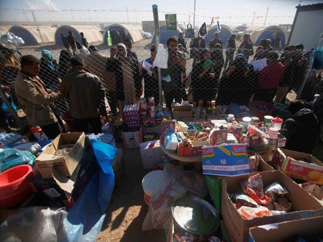 Displaced Iraqi people, who fled the Islamic State stronghold of Mosul, stand in line to receive aid at Khazer camp in Iraq on Tuesday.(Reuters) Displaced Iraqi people, who fled the Islamic State stronghold of Mosul, stand in line to receive aid at Khazer camp in Iraq on Tuesday.(Reuters)