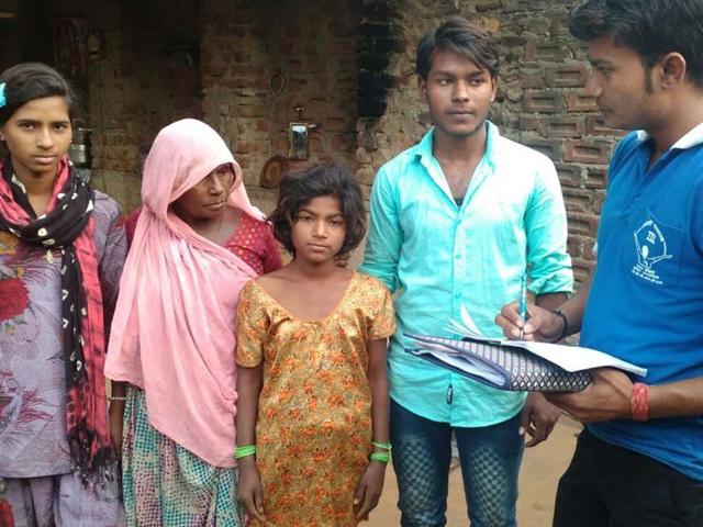 Ladli Samman Campaign volunteer taking details from a woman in Deoli in Tonk while her grand children look on.(HT Photo)