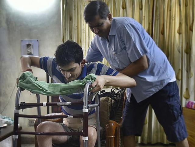 Ram Karan Rai helping his 24-year- old son Ravi Rai who was admitted in Fortis Shalimar Bagh for a heel fracture, was operated on the wrong leg.(Raj K Raj/Hindustan Times)