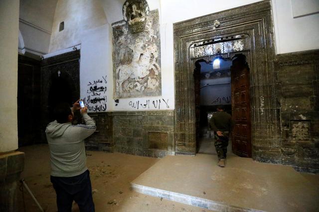 People take pictures at the Mar Behnam monastery after the town was recaptured from the Islamic State, in Ali Rash, southeast of Mosul, Iraq. (Reuters) People take pictures at the Mar Behnam monastery after the town was recaptured from the Islamic State, in Ali Rash, southeast of Mosul, Iraq. (Reuters)